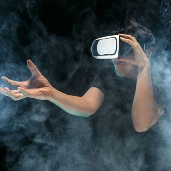The man with glasses of virtual reality. Future technology concept. Black studio smoky background