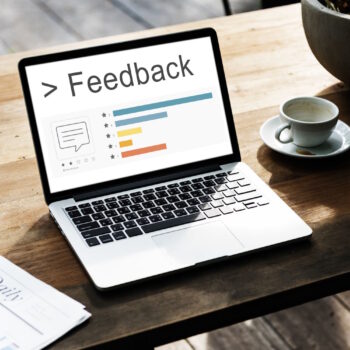 מחשב נייד פתוח ועל המסך שלו כתוב feedback